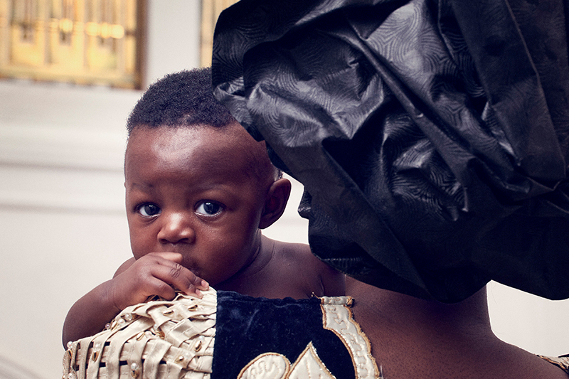 Small black child held by mother